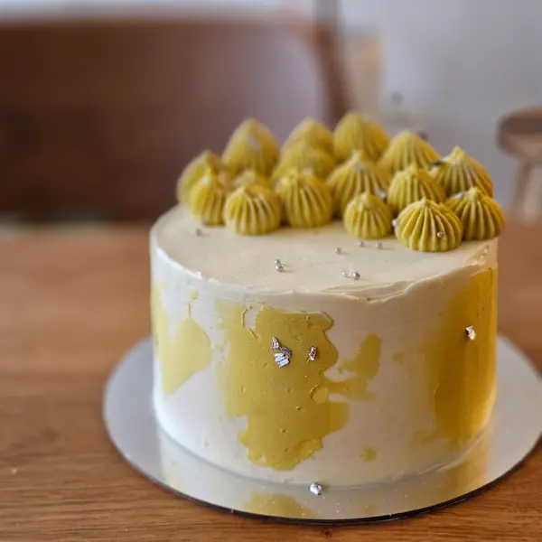 Yellow painted cake with piped buttercream top
