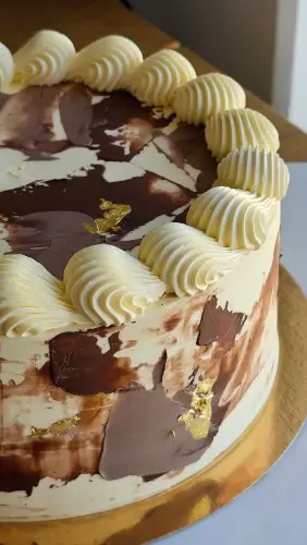 Chocolate painted cake with cream piping