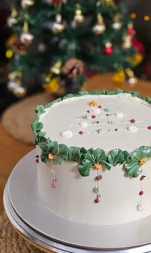 White cake with green piping and floral details