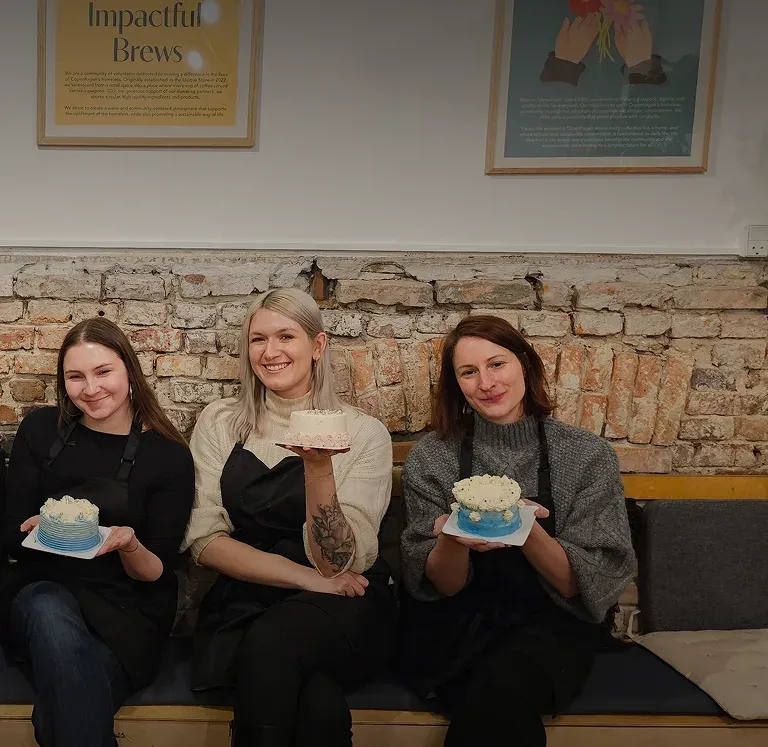 Workshop participants smiling with their finished buttercream cakes